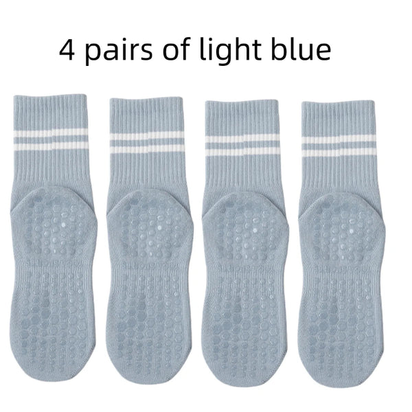 Set of 4 women’s non-slip grip socks in black, white, pink, and gray for yoga, Pilates, and ballet workouts.